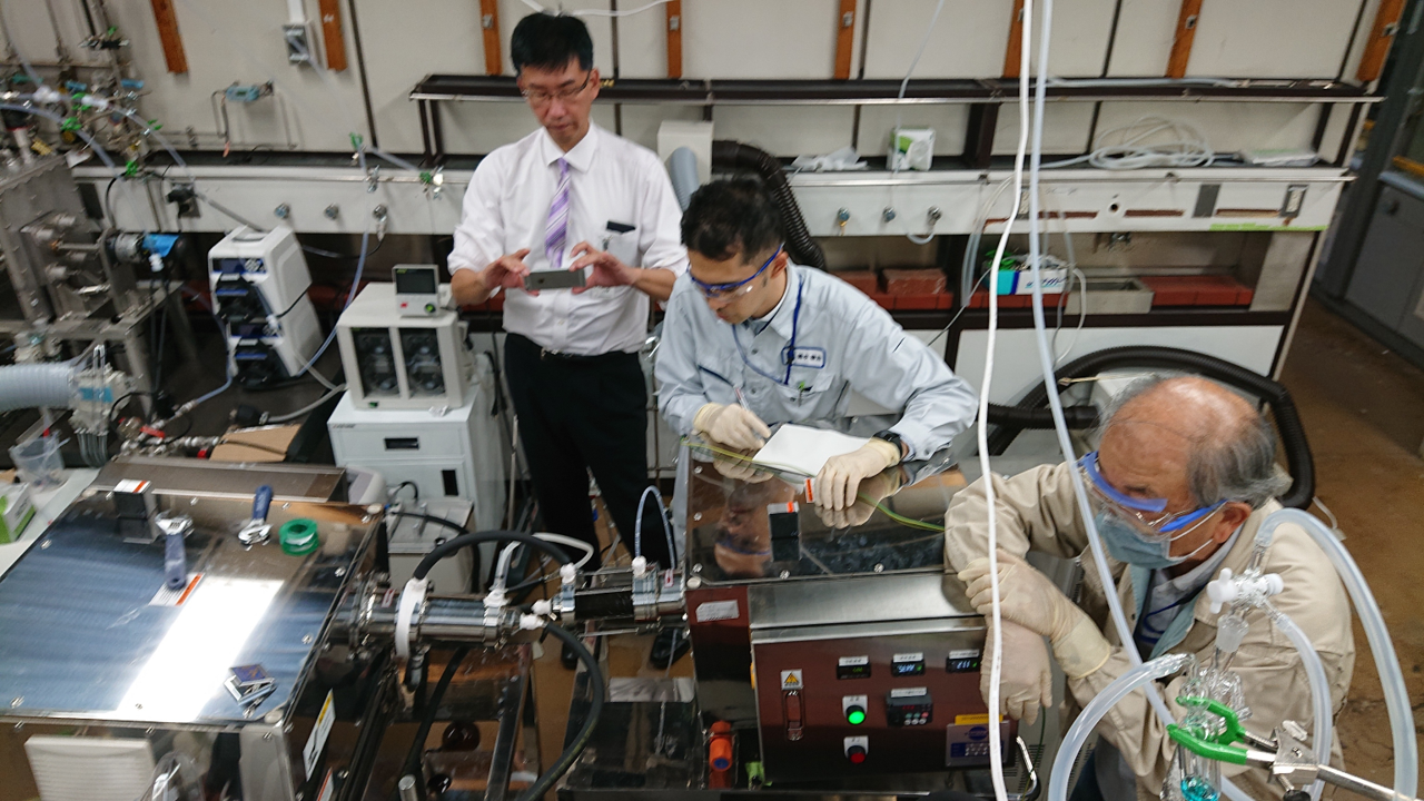 写真7 産総研で実験する鶴本さんたち.png