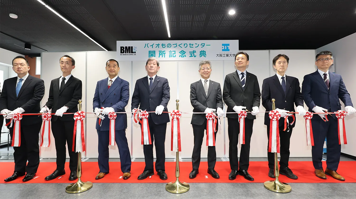 開所式でのテープカットの様子。左から順に、バイオインダストリー協会 田中専務理事、NEDO 林理事、経済産業省近畿経済産業局地域経済部 大平次長、常翔学園 西村理事長、大阪工業大学 井上学長、大阪府商工労働部 東口部長、千葉大学 関名誉教授・プロジェクトリーダー、バイオものづくりセンター 長森センター長